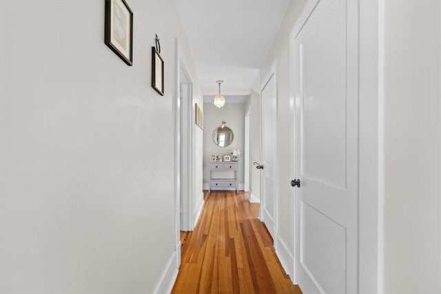 hall with baseboards and light wood finished floors