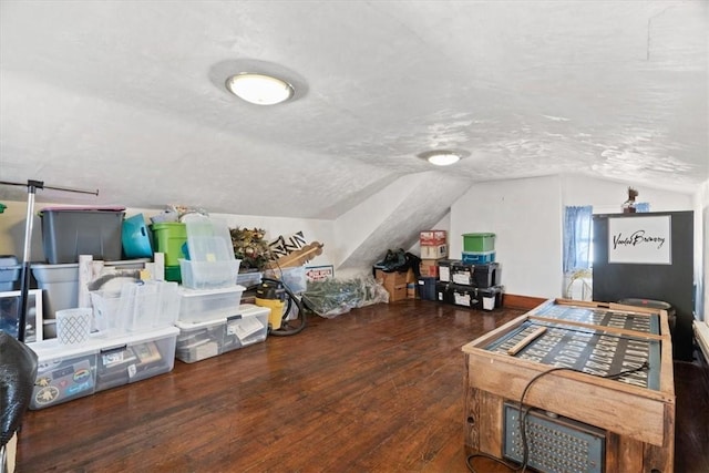 bedroom with wood-type flooring, a textured ceiling, and lofted ceiling