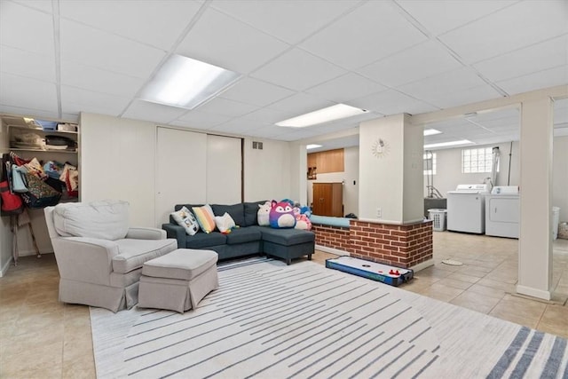 tiled living area with visible vents, a paneled ceiling, and separate washer and dryer