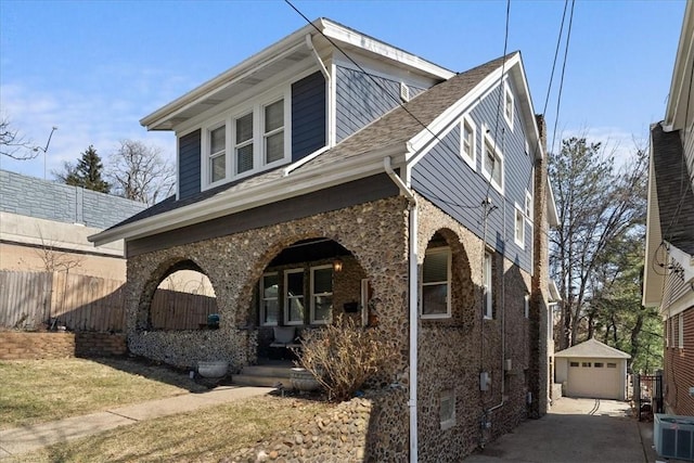 view of front of home featuring an outbuilding, driveway, covered porch, central AC, and a garage