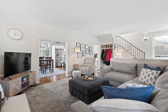 living area with stairway, baseboards, and wood finished floors