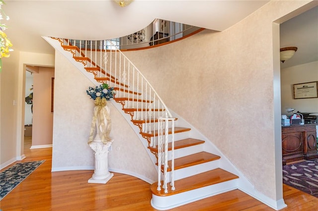 stairway featuring baseboards and wood finished floors