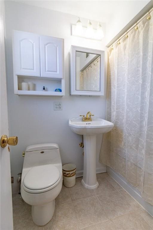 full bathroom with a sink, curtained shower, baseboards, and toilet