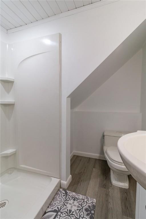 full bath with a shower stall, toilet, baseboards, and wood finished floors