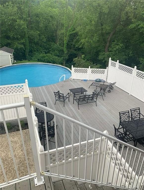 pool with a view of trees and a wooden deck
