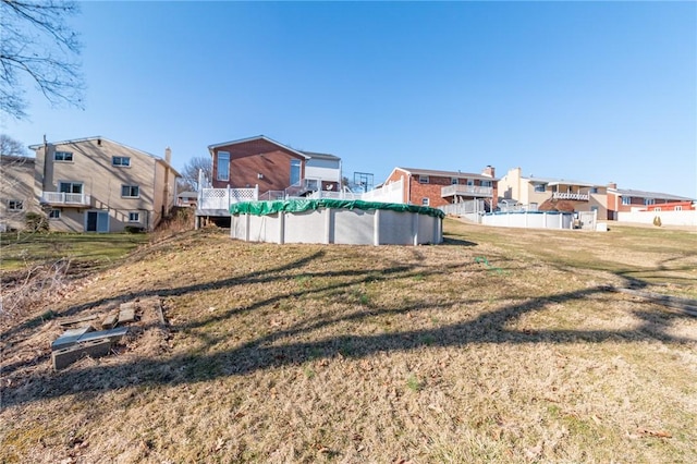 view of yard featuring a covered pool and a residential view