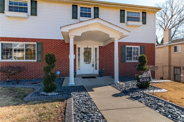 doorway to property featuring brick siding