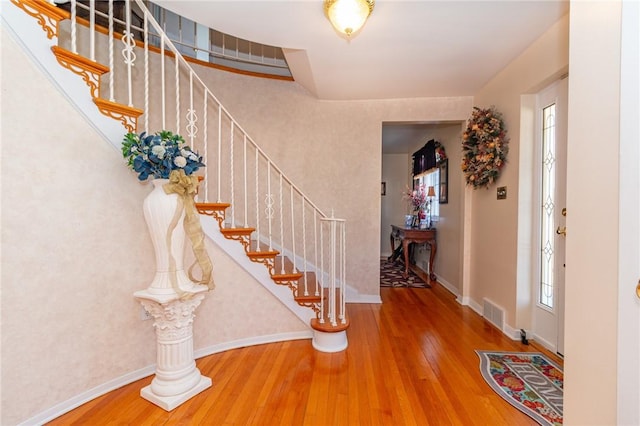 foyer entrance featuring visible vents, baseboards, and hardwood / wood-style floors