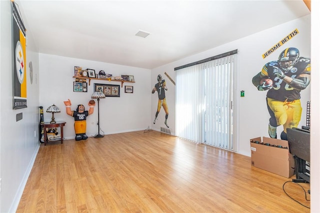 unfurnished room with visible vents, baseboards, and wood finished floors