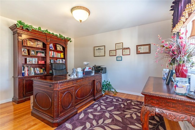 office space with baseboards and light wood finished floors