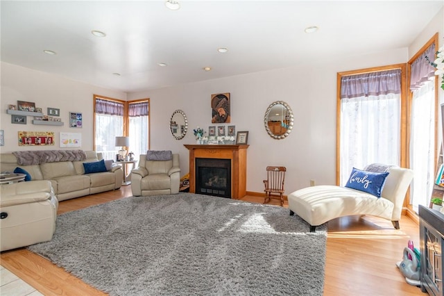 living room with recessed lighting, wood finished floors, and a fireplace