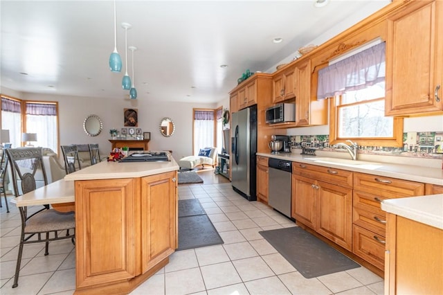 kitchen with a sink, stainless steel appliances, a wealth of natural light, and open floor plan