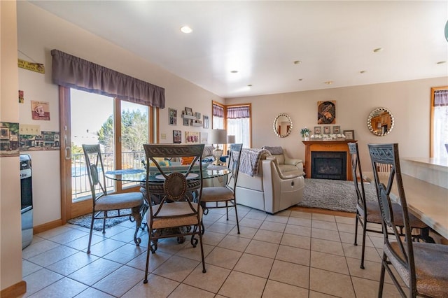 dining area with light tile patterned flooring, a fireplace, recessed lighting, and baseboards