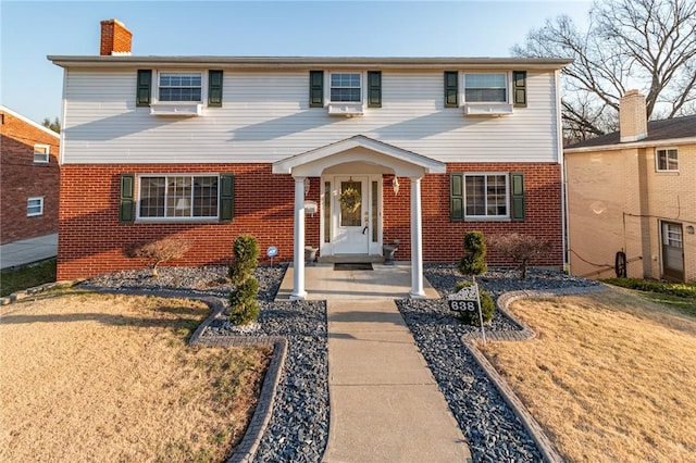view of front of home with brick siding and a chimney