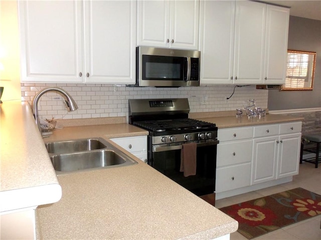 kitchen featuring white cabinetry, stainless steel appliances, light countertops, and a sink