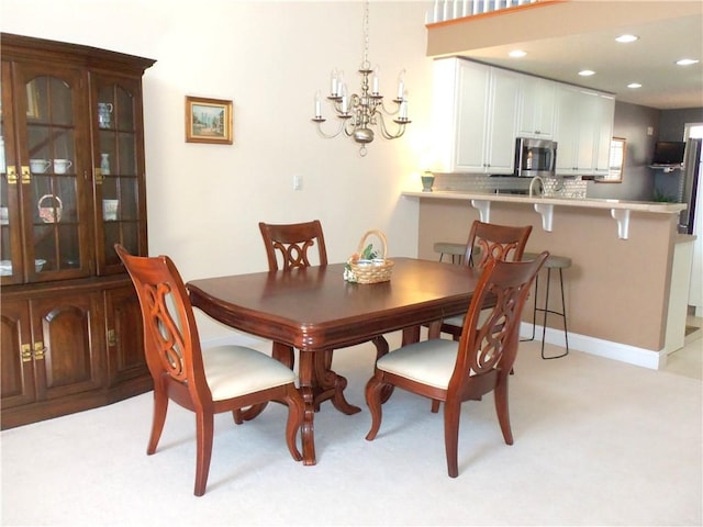 dining space with recessed lighting, light colored carpet, and a chandelier