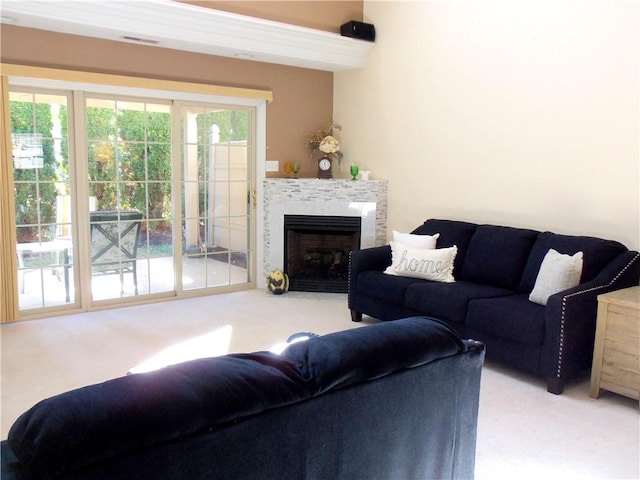 carpeted living room with a fireplace with flush hearth