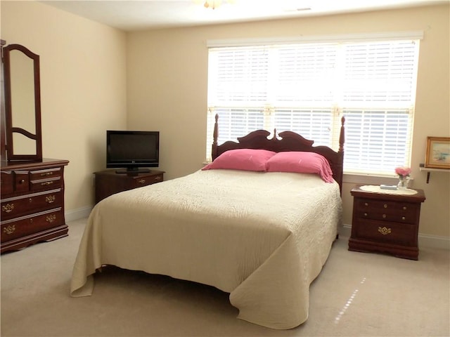 bedroom with baseboards and light colored carpet