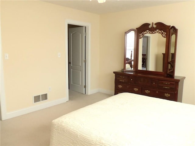 bedroom featuring baseboards, visible vents, and light carpet