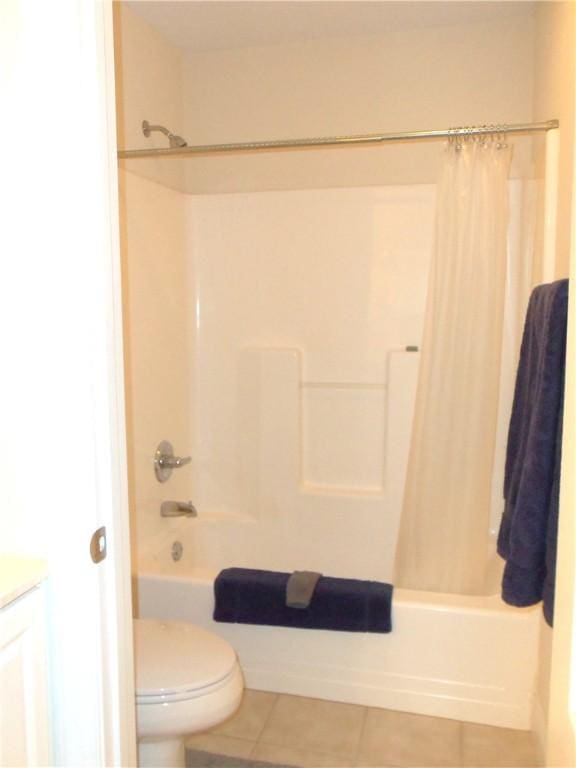 bathroom featuring tile patterned floors, shower / bath combination with curtain, toilet, and vanity