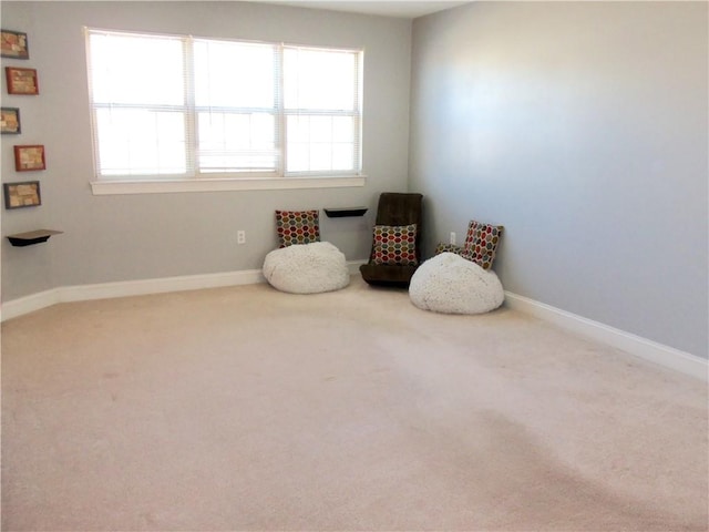 living area with baseboards and carpet