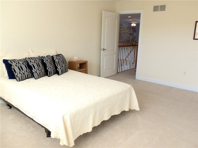 bedroom featuring light carpet, visible vents, and baseboards