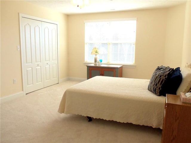 bedroom with a closet, baseboards, and carpet flooring