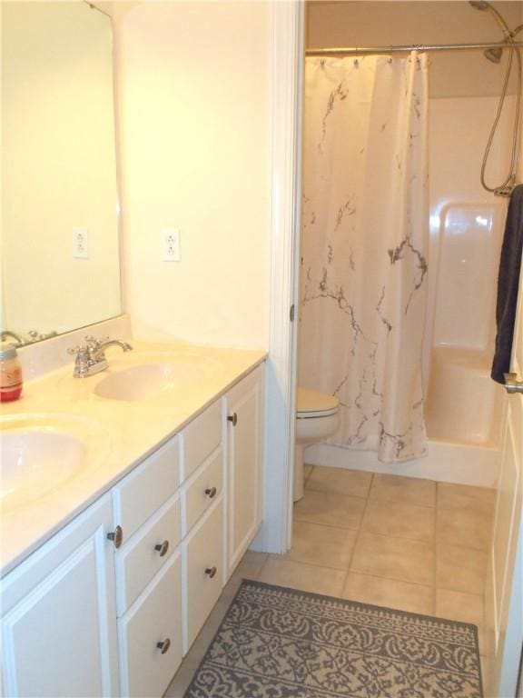 bathroom with double vanity, a sink, tile patterned flooring, curtained shower, and toilet