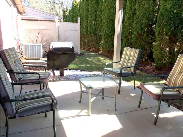 view of patio with central air condition unit, fence, and grilling area