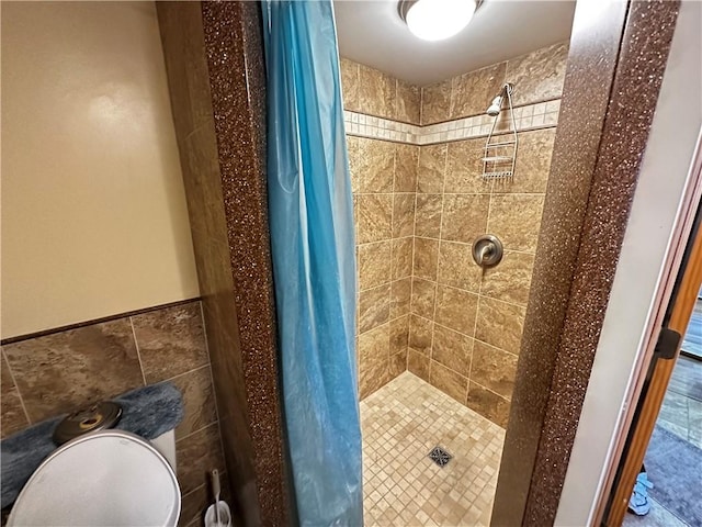 bathroom featuring tile walls and a stall shower