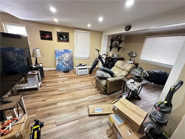 workout area featuring recessed lighting, baseboards, a wealth of natural light, and light wood-style flooring