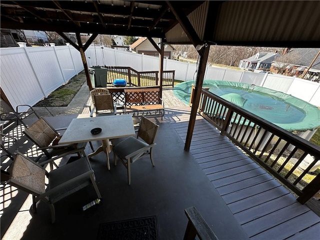 wooden deck with a fenced in pool, a patio, outdoor dining area, and a fenced backyard