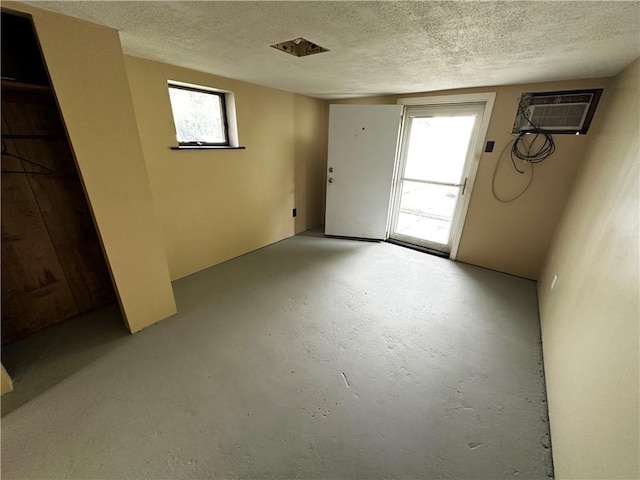 39 Dunkard Ave, Uniontown, PA 15401 - interior space featuring an AC wall unit, a textured ceiling, and concrete floors