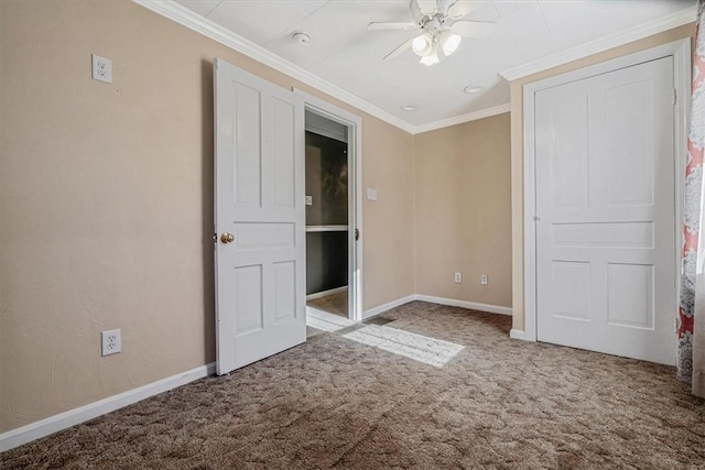 unfurnished bedroom featuring crown molding, carpet flooring, and baseboards