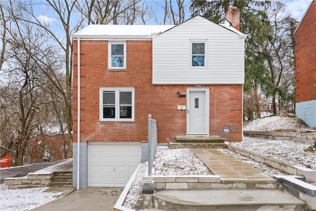 view of front of house featuring driveway, brick siding, an attached garage, and a chimney