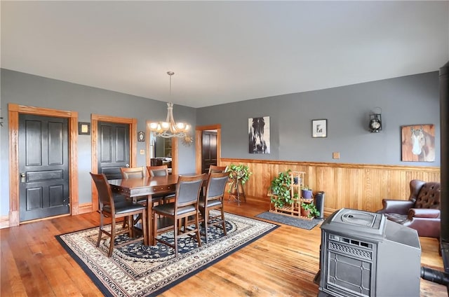 dining area featuring a notable chandelier, wainscoting, and hardwood / wood-style flooring