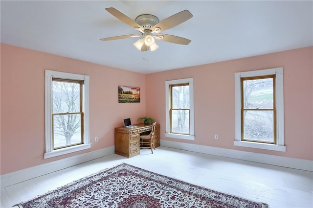 unfurnished office featuring baseboards and ceiling fan