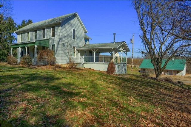 view of side of property featuring a lawn and a sunroom