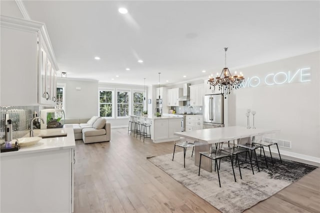 dining space featuring recessed lighting, light wood-style floors, baseboards, and ornamental molding