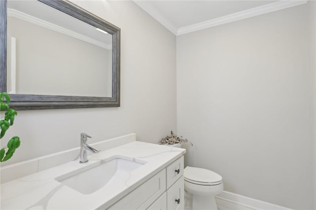 bathroom with baseboards, toilet, vanity, and crown molding