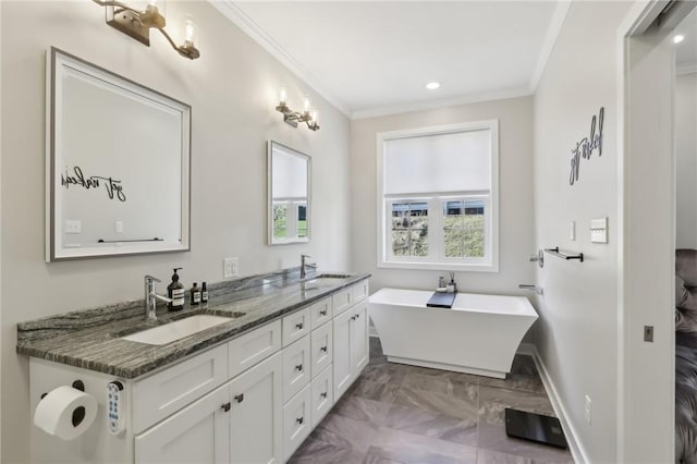 bathroom featuring crown molding, a soaking tub, double vanity, and a sink