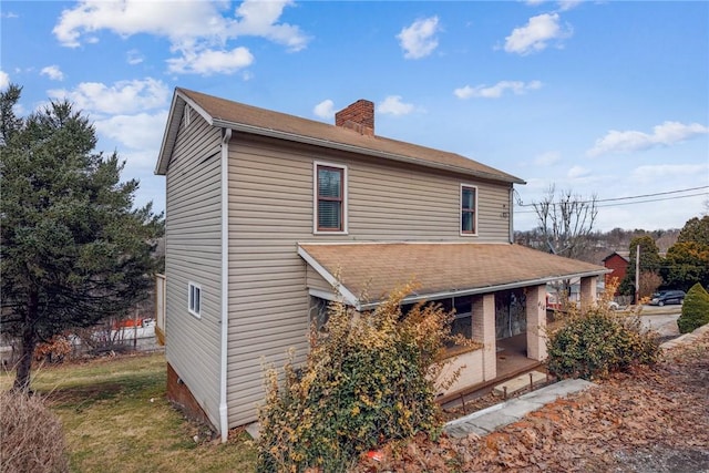 rear view of property featuring a chimney