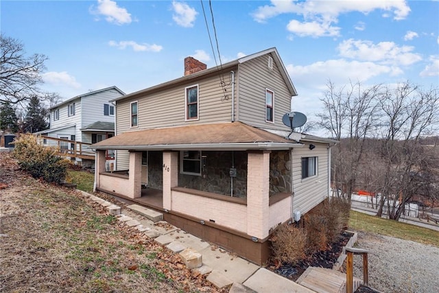 view of front of home featuring brick siding and a chimney