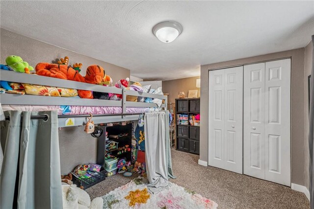 carpeted bedroom featuring a closet, a textured ceiling, and baseboards