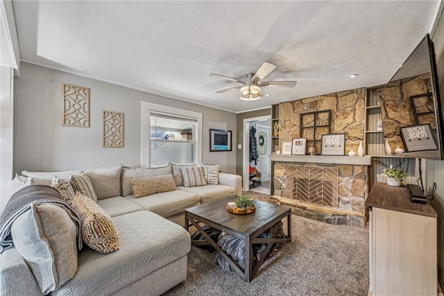 carpeted living room with a ceiling fan, a textured ceiling, and a fireplace