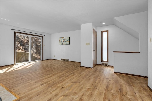 interior space featuring baseboards, visible vents, and light wood finished floors