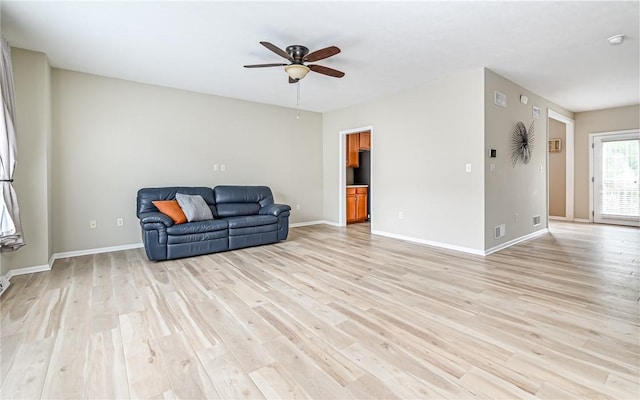 sitting room featuring ceiling fan, baseboards, and light wood-style floors