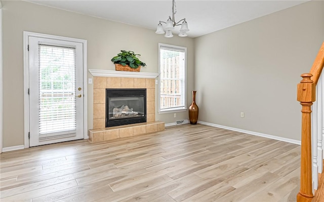 unfurnished living room with a healthy amount of sunlight, light wood-style flooring, and a fireplace