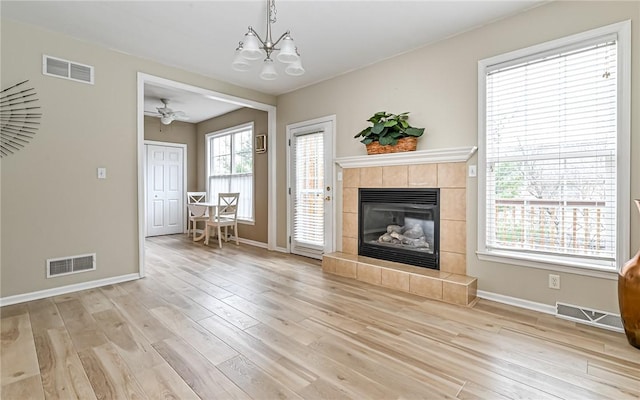 unfurnished living room featuring light wood finished floors, visible vents, and a fireplace