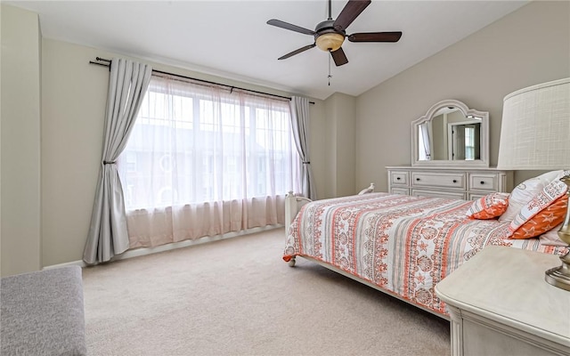 carpeted bedroom featuring ceiling fan and vaulted ceiling